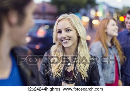 Two young couples walk down a popular street at dusk, focus is on a young woman with blond hair; Edmonton, Alberta, Canada View Large Photo Image Stock Photograph - Two young couples walk down a popular street at dusk, focus is on a young woman with blond hair; Edmonton, Alberta, Canada. Fotosearch