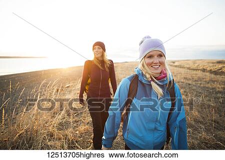 Two young women hiking along the coast at sunrise; Anchorage, Alaska, United States of America View Large Photo Image Stock Photograph - Two young women hiking along the coast at sunrise; Anchorage, Alaska, United States of America. Fotosearch