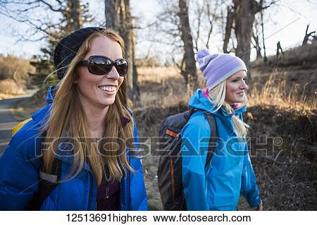 Stock Photograph - Two young women on a hike on a trail; Anchorage, Alaska, United States of America. Fotosearch