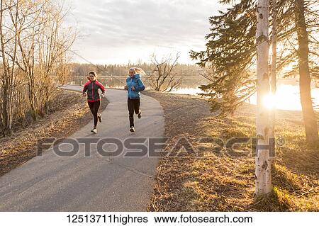 Two young women running on a trail at the water's edge; Anchorage, Alaska, United States of America View Large Photo Image Stock Photograph - Two young women running on a trail at the water's edge; Anchorage, Alaska, United States of America. Fotosearch