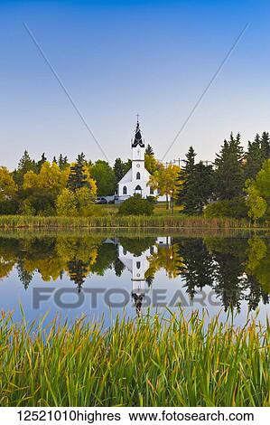 Stock Photograph - Ukrainian Catholic Church reflected in a lake; Camrose, Alberta, Canada. Fotosearch