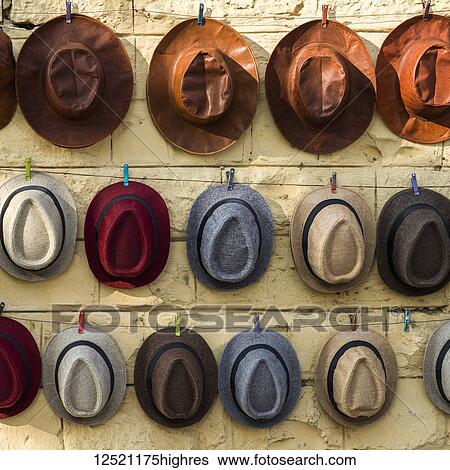 Various styles of hats hanging on display in a row on a wall; Jaisalmer, Rajasthan, India View Large Photo Image Stock Photograph - Various styles of hats hanging on display in a row on a wall; Jaisalmer, Rajasthan, India. Fotosearch