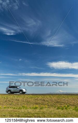 Vehicle driving on open road near Hella with Hekla volcano in the distance; Iceland View Large Photo Image Stock Photograph - Vehicle driving on open road near Hella with Hekla volcano in the distance; Iceland. Fotosearch