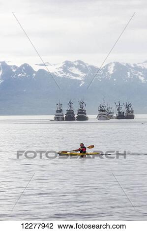 View of a kayaker in front of a group of seine fishing boats in Lynn Canal near Juneau, Southeast Alaska, Summer. View Large Photo Image Stock Image - View of a kayaker in front of a group of seine fishing boats in Lynn Canal near Juneau, Southeast Alaska, Summer.. Fotosearch