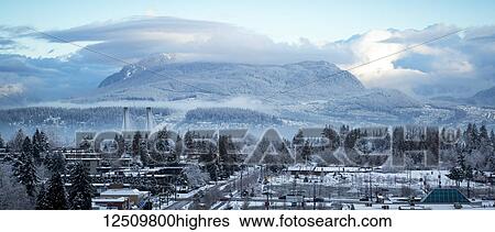 View of clouds hovering over mountains and snow covering the neighbourhood in the foreground; Surrey, British Columbia, Canada View Large Photo Image Stock Photograph - View of clouds hovering over mountains and snow covering the neighbourhood in the foreground; Surrey, British Columbia, Canada. Fotosearch