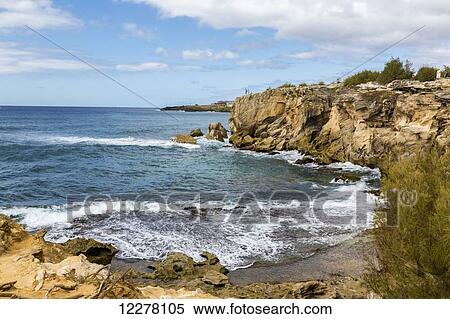 View of three tourists stand on a cliff watching waves break over rock below; Poipu, Kauai, Hawaii, United States of America View Large Photo Image Stock Photography - View of three tourists stand on a cliff watching waves break over rock below; Poipu, Kauai, Hawaii, United States of America. Fotosearch