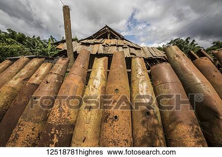 Stock Photograph - Wall made from bomb casings in Na Kam Peng, also called Bomb Village; Na Kam Peng, Xiangkhouang, Laos. Fotosearch