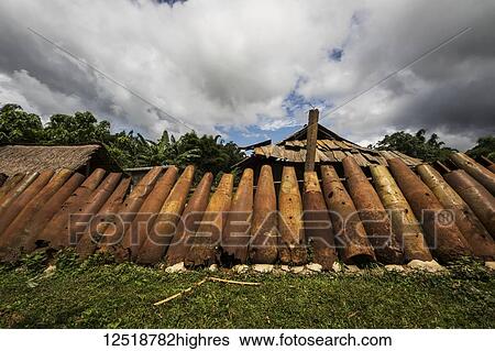 Stock Photograph - Wall made from bomb casings in Na Kam Peng, also called Bomb Village; Na Kam Peng, Xiangkhouang, Laos. Fotosearch