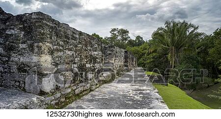 Stock Photograph - Weathered stone wall and path in a Mayan village; San Jose Succotz, Cayo District, Belize. Fotosearch