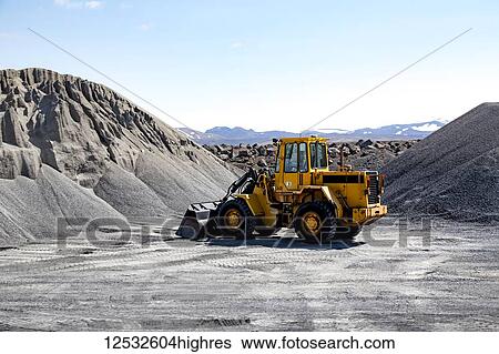 Wide angle view of a large wheel loader heavy equipment machine parked in front of a gravel pile in the mountain landscape; Iceland View Large Photo Image Stock Photograph - Wide angle view of a large wheel loader heavy equipment machine parked in front of a gravel pile in the mountain landscape; Iceland. Fotosearch