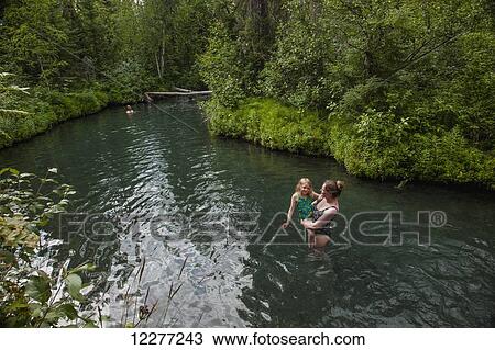 Stock Image - Woman and daughter in Liard Hot Springs, British Columbia, Canada, summer. Fotosearch