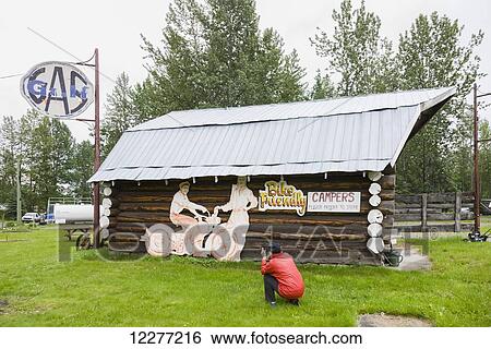 Woman tourist photographs a log cabin at the Tetsa River Lodge, British Columbia, Canada, Summer View Large Photo Image Stock Photograph - Woman tourist photographs a log cabin at the Tetsa River Lodge, British Columbia, Canada, Summer. Fotosearch
