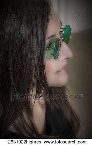 Stock Photograph - Woman wearing round green glasses; Connecticut, United States of America. Fotosearch