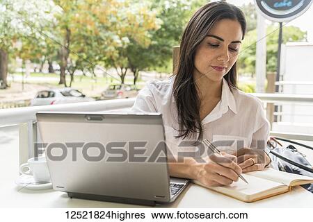 Stock Photograph - Woman working on her computer at a cafe; Cochabamba, Bolivia. Fotosearch