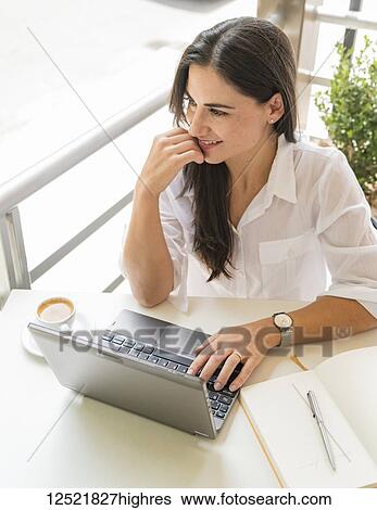 Woman working on her computer at a cafe; Cochabamba, Bolivia View Large Photo Image Stock Photograph - Woman working on her computer at a cafe; Cochabamba, Bolivia. Fotosearch