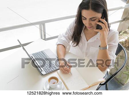 Stock Photograph - Woman working on her computer at a cafe; Cochabamba, Bolivia. Fotosearch