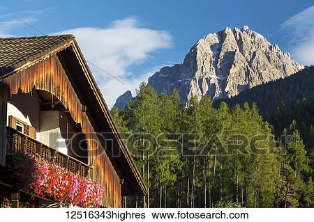 Wooden alpine chalet with flower boxes and mountain in the background with blue sky and clouds; Grainau, Bavaria, Germany View Large Photo Image Stock Photograph - Wooden alpine chalet with flower boxes and mountain in the background with blue sky and clouds; Grainau, Bavaria, Germany. Fotosearch