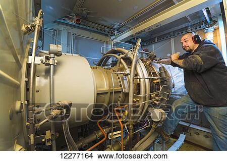 Worker working on an electrical power plant, gas turbine generator and drive shaft, Prudhoe Bay, Arctic Alaska, USA, Summer View Large Photo Image Picture - Worker working on an electrical power plant, gas turbine generator and drive shaft, Prudhoe Bay, Arctic Alaska, USA, Summer. Fotosearch