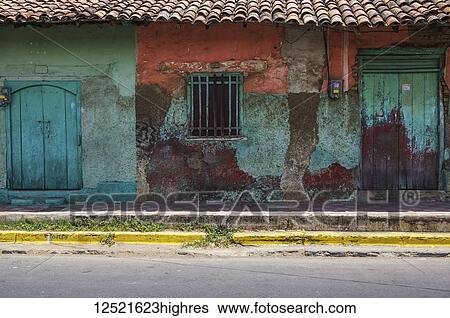 Stock Photograph - Worn and weathered facade of a building with peeling paint and double doors; Nicaragua. Fotosearch