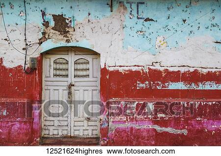 Stock Photograph - Worn and weathered facade of a building with peeling paint and double doors; Nicaragua. Fotosearch