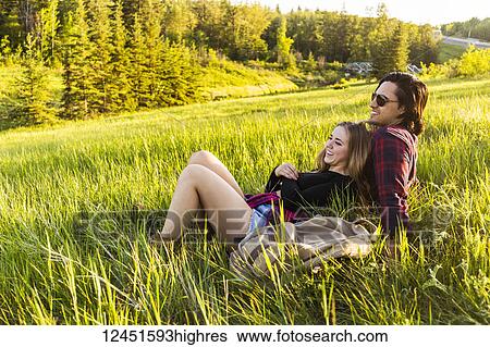 Young couple in a park sitting to rest during a hike in autumn; Edmonton, Alberta, Canada View Large Photo Image Stock Photograph - Young couple in a park sitting to rest during a hike in autumn; Edmonton, Alberta, Canada. Fotosearch