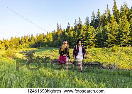 Young couple walking together on a hike in a city park in autumn; Edmonton, Alberta, Canada View Large Photo Image Stock Photograph - Young couple walking together on a hike in a city park in autumn; Edmonton, Alberta, Canada. Fotosearch