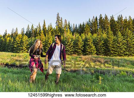 Young couple walking together on a hike in a city park in autumn; Edmonton, Alberta, Canada View Large Photo Image Stock Photograph - Young couple walking together on a hike in a city park in autumn; Edmonton, Alberta, Canada. Fotosearch
