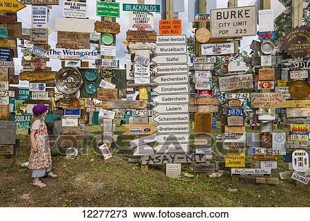 Stock Image - Young girl explores the Signpost Forest, Watson Lake, Yukon Territory, Canada, summer. Fotosearch