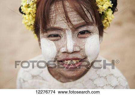 Young girl with white face paint and flowers in her hair; Bagan, Myanmar View Large Photo Image Picture - Young girl with white face paint and flowers in her hair; Bagan, Myanmar. Fotosearch