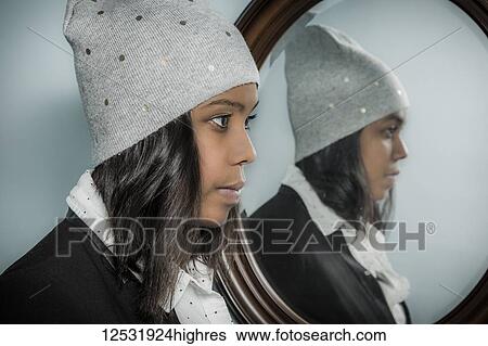 Young hispanic woman wearing a knit hat with her reflection in a mirror; Connecticut, United States of America View Large Photo Image Stock Photograph - Young hispanic woman wearing a knit hat with her reflection in a mirror; Connecticut, United States of America. Fotosearch