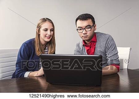 Young millennial business professionals working together in a conference room in a high tech modern business; Sherwood Park, Alberta, Canada View Large Photo Image Stock Photograph - Young millennial business professionals working together in a conference room in a high tech modern business; Sherwood Park, Alberta, Canada. Fotosearch