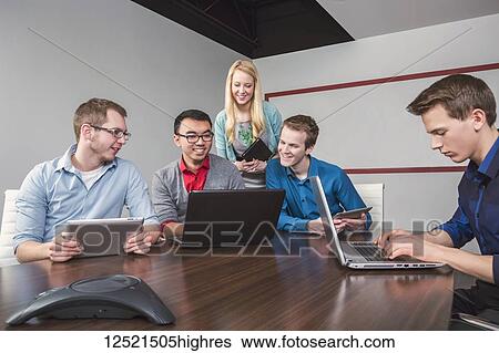 Young millennial business professionals working together in a conference room in a high tech modern business; Sherwood Park, Alberta, Canada View Large Photo Image Stock Photograph - Young millennial business professionals working together in a conference room in a high tech modern business; Sherwood Park, Alberta, Canada. Fotosearch