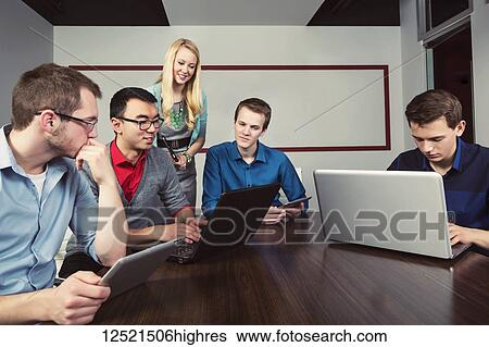 Stock Photograph - Young millennial business professionals working together in a conference room in a high tech modern business; Sherwood Park, Alberta, Canada. Fotosearch