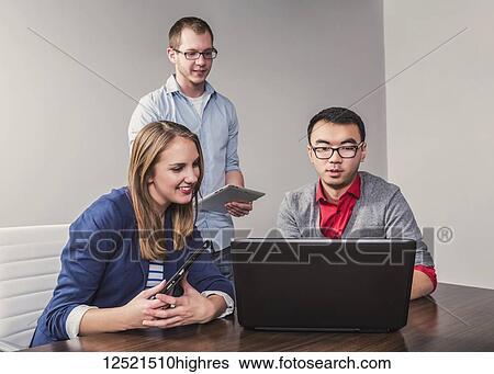 Young millennial business professionals working together in a conference room in a high tech modern business; Sherwood Park, Alberta, Canada View Large Photo Image Stock Photograph - Young millennial business professionals working together in a conference room in a high tech modern business; Sherwood Park, Alberta, Canada. Fotosearch