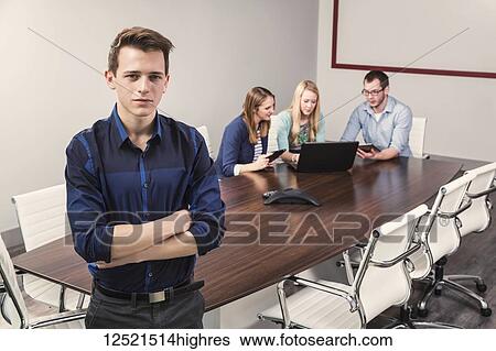 Young millennial business professionals working together in a conference room in a high tech modern business; Sherwood Park, Alberta, Canada View Large Photo Image Stock Photograph - Young millennial business professionals working together in a conference room in a high tech modern business; Sherwood Park, Alberta, Canada. Fotosearch