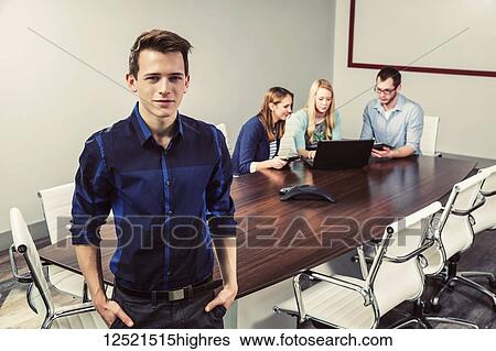 Young millennial business professionals working together in a conference room in a high tech modern business; Sherwood Park, Alberta, Canada View Large Photo Image Stock Photograph - Young millennial business professionals working together in a conference room in a high tech modern business; Sherwood Park, Alberta, Canada. Fotosearch