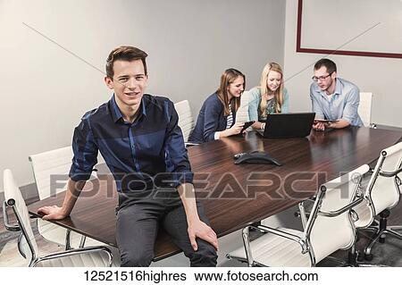 Stock Photograph - Young millennial business professionals working together in a conference room in a high tech modern business; Sherwood Park, Alberta, Canada. Fotosearch