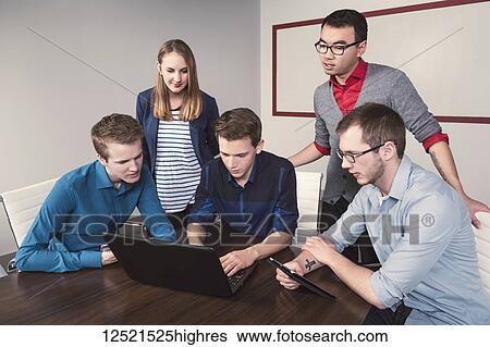 Young millennial business professionals working together in a conference room in a high tech modern business; Sherwood Park, Alberta, Canada View Large Photo Image Stock Photograph - Young millennial business professionals working together in a conference room in a high tech modern business; Sherwood Park, Alberta, Canada. Fotosearch