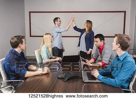 Young millennial business professionals working together in a conference room in a place of business and praising the efforts of one of their peers; Sherwood Park, Alberta, Canada View Large Photo Image Stock Photograph - Young millennial business professionals working together in a conference room in a place of business and praising the efforts of one of their peers; Sherwood Park, Alberta, Canada. Fotosearch