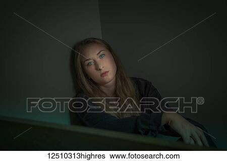 Young woman sitting in a corner with intense green eyes looking at the camera View Large Photo Image Stock Photograph - Young woman sitting in a corner with intense green eyes looking at the camera. Fotosearch