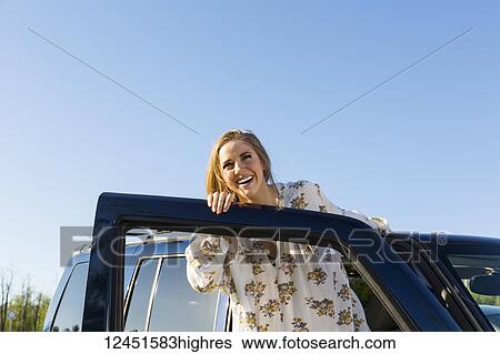Young woman with long blond hair posing for the camera at the open door of a vehicle; Edmonton, Alberta, Canada View Large Photo Image Stock Photograph - Young woman with long blond hair posing for the camera at the open door of a vehicle; Edmonton, Alberta, Canada. Fotosearch
