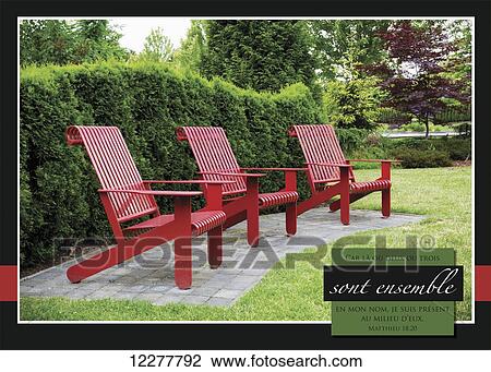 Stock Image - 3 red chairs at Fleetwood Public Park and French scripture; Surrey, British Columbia, Canada. Fotosearch
