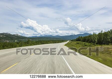 Stock Photo - A Motion Blurred Alaska Highweay alongside the Liard River, North of Liard Hot Springs, British Columbia, Canada . Fotosearch