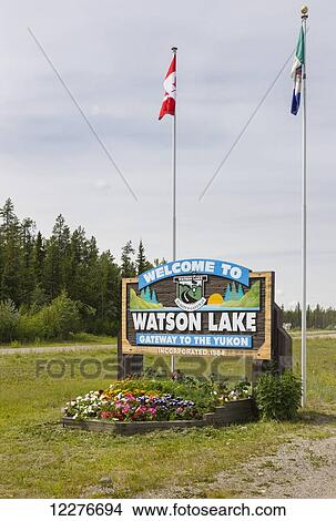 A Welcome to Watson Lake sign with flags in the background, Yukon Territory, Canada, Summer View Large Photo Image Picture - A Welcome to Watson Lake sign with flags in the background, Yukon Territory, Canada, Summer. Fotosearch