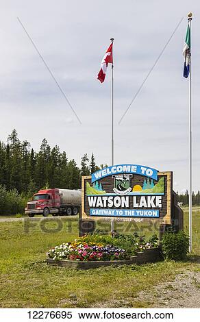 A Welcome to Watson Lake sign with flags in the background, Yukon Territory, Canada, Summer View Large Photo Image Stock Photography - A Welcome to Watson Lake sign with flags in the background, Yukon Territory, Canada, Summer. Fotosearch