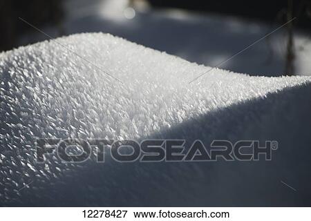 Stock Photo - An organic-shaped mound of ice crystals half in sun, half shade; Whistler, British Columbia, Canada. Fotosearch