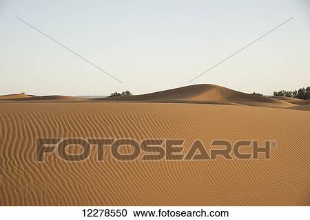 Stock Image - Desert dunes landscape late in the day, Sahara Desert; Merzouga, Morocco. Fotosearch