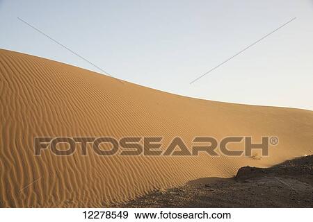 Stock Photo - Desert dunes landscape late in the day, Sahara Desert; Merzouga, Morocco. Fotosearch