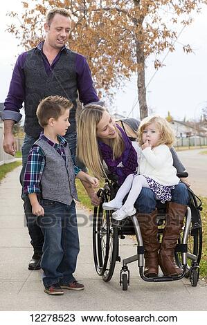 Stock Image - Disabled young mother spending quality time with her family outdoors; Spruce Grove, Alberta, Canada. Fotosearch