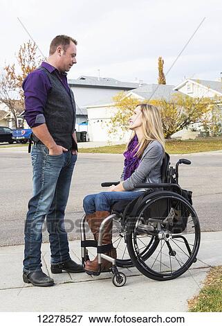 Stock Photo - Husband and wife with disability spending time together outdoors; Spruce Grove, Alberta, Canada. Fotosearch